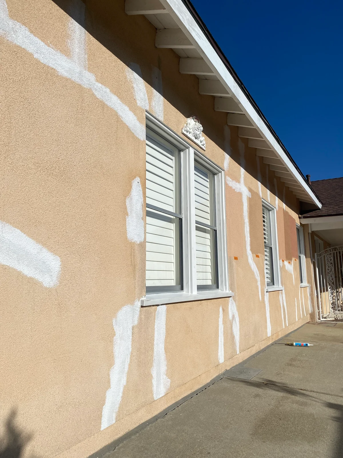 Huff Painting crew patching and priming stucco on a foothill home before repainting